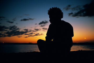 A silhouette of a person deep in thought, gazing into the sunset, evoking contemplation and philosophical reflection.