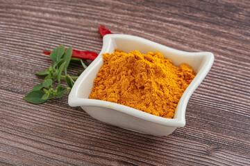 Yellow vibrant curcuma powder in the bowl