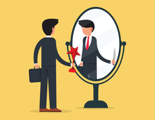 Behind business success. Young businessman holding a trophy looks at his reflection in the mirror.