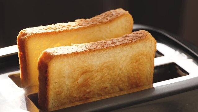 Appetizing golden slices of toasted bread emerge from the toaster oven. Slowly the toast jumps. Breakfast. In the sunny morning light,