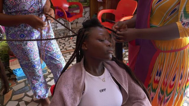 Hairstylist busy twisting and turning extensions on head of young female