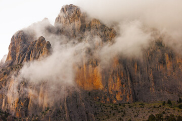 Mountains in the clouds. View of the mountain peak in the fog. Beautiful landscape with high cliffs. Dedegol. Turkey.