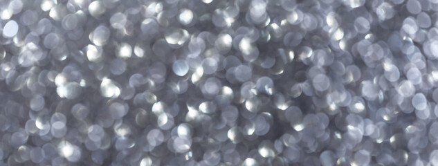 Blurred silver background with circle sparkling lights. Shiny gray glittery bokeh of christmas...