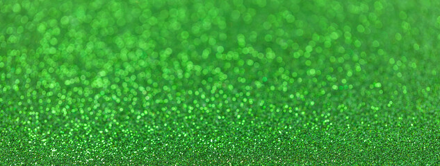 Blurred green sparkling background from small sequins for new year or christmas, macro. Defocused...