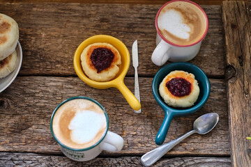 Syrnik with cherry sauce on a wooden background.
cheese pancake. 