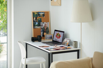 Printed photos on desk of photographer in his home office