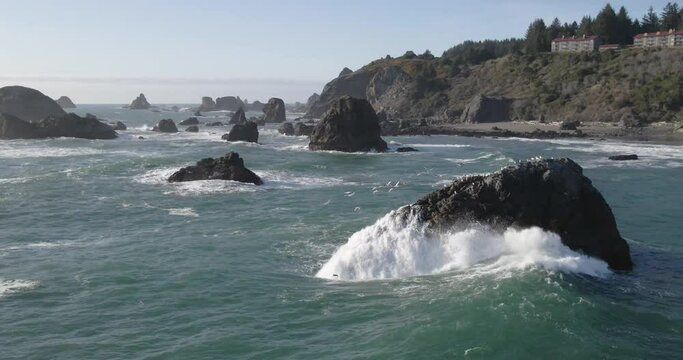 4K Drone footage of wave crashing onto rock cliff with seagulls flying brookings oregon