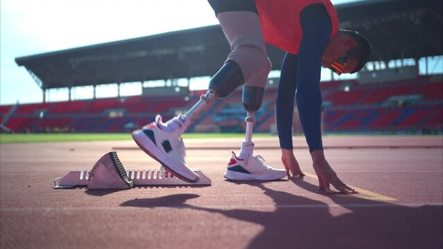Disabled athletes prepare in starting position ready to run on stadium track