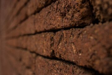 Laterite Stone wall surface red stone brick blocks  background with selective focus