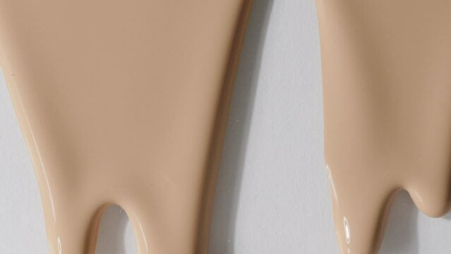 Foundation  makeup smear, concealer, cosmetic liquid foundation, or cream beige color smudge flowing down