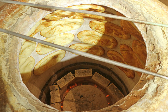 Group of Armenian traditional breads being baked in a modern gas tonir oven