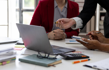 Close up Team of colleagues discussing business Accounting using calculating income-expenditure and calculator analyzing real estate investment data report Financial and tax systems concept.