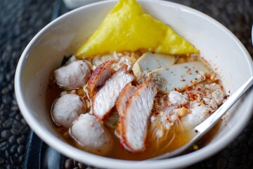 Asian noodle soup with beef meatball with fresh vegetable on wood table vintage style, street food, hot and spicy noodle soup, asian food.