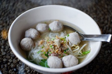 Asian noodle soup with beef meatball with fresh vegetable on wood table vintage style, street food, hot and spicy noodle soup, asian food.