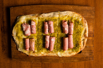 Pizza with mozzarella, pistachio pesto and mortadella sausage
