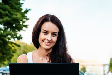 Happy smiling businesswoman brunette working on a laptop in a street cafe.Start-up concept.Closeup.