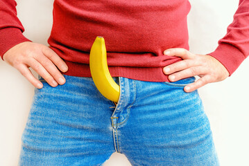 A Man and banana on the white background,close-up.Potency concept, impotence, male strength, pills...