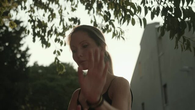 Morning practice. A young woman moves gracefully while doing qigong exercises alone in nature. Do gymnastics at dawn, solitude, longevity. Peace of mind and body, harmony of body and spirit 