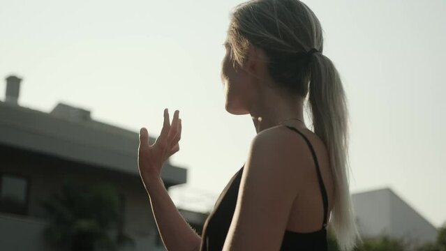 Peaceful woman doing oriental practice at dawn, moving slowly. Spiritual practice, qigong, balance. Close-up. Solitude, time with yourself. Spiritual practice.
