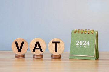 close up stack of coin, tax wooden text block and 2024 small calendar on wood table, saving and...