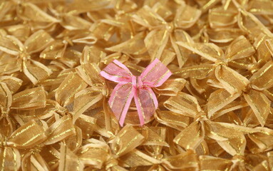 a gold bow ribbon on pink bows ribbon background