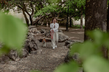 Fototapeta premium Young girl with beagle dog walking in summer