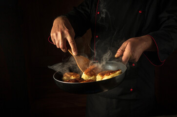 The chef fries dough donuts in a frying pan. Place for hotel menu or recipe on black background