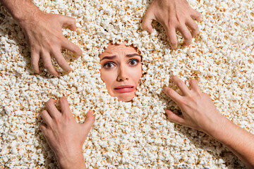High view portrait of crazy worried lady scared zombie people arms face buried inside popcorn...
