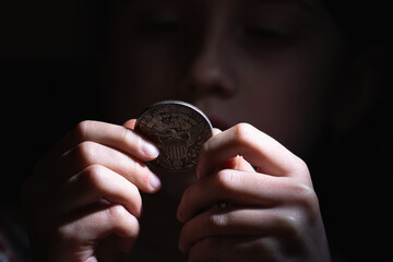 Close up US Dollar (antique coins) in palm of woman hand on dark  background as a symbol of...