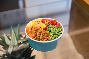 Bowl of delicious dish with fresh seafood and sauce placed on glass top of table