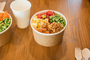Bowl of delicious healthy poke with fruits at cafe