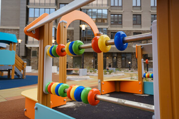 Children's entertainment multi-colored device on playground near an apartment building