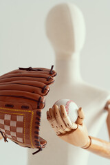 Wooden hands holding a baseball glove and a ball. Bright photo on a white background.