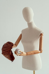 Wooden hands holding a baseball glove and a ball. Bright photo on a white background.