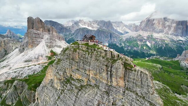 Aerial view of Rifugio Nuvolau, the oldest mountain hut refuge in the Dolomites, Italy. Clouds covering the mountains in the background. Beautiful destinations for hikers and alpinists. Cinematic shot