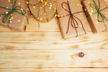 Christmas background. Gifts wrapping in brown paper on a light wooden background. Top view