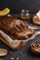 Banana bread on a dark background. Homemade cakes with banana and nuts.