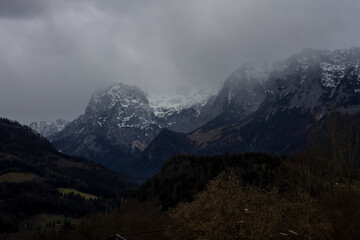 Mountain landscape with snow-covered peaks under a cloudy sky in spring