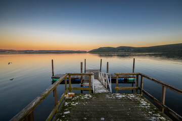 Fototapeta na wymiar Knysna Lagoon with jetty and fishing boats at sunset in the Garden Route South Africa