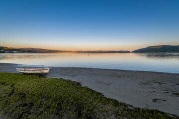 Knysna Lagoon with jetty and fishing boats at sunset in the Garden Route South Africa