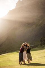 A group of girls tourists in colorful national Icelandic sweaters at sunset 