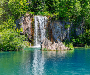 Fototapeta na wymiar Picturesque waterfall. Waterfall among rocks and forest. Plitvice Lakes, Croatia.