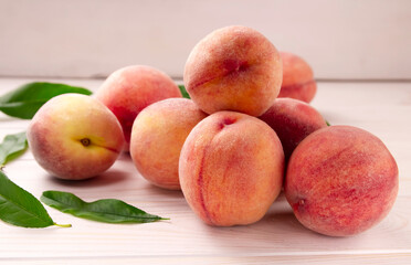 Fototapeta na wymiar Fresh peaches on a wooden table. Summer peach fruit background.