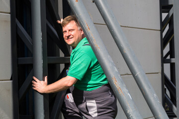 A worker climbs metal structures onto a building.