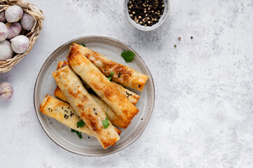 Turkish Cigara Börek (Sigara böreği) or Cigarette Pastry with Spinach and Feta Cheese with yogurt dip. Finger food. Spring rolls. Top view
