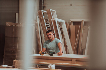 A skilled worker in the woodworking industry adeptly utilizes modern machinery to process and...