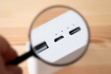 Magnifying glass on Micro USB port on power bank. Using micro usb port for charging gadgets concept