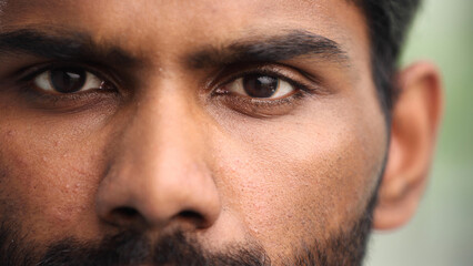 Obraz premium Close up portrait of a young serious man looking at the camera. He is open and serious.