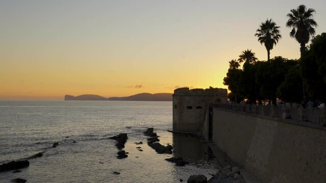 Historic wall of Alghero city at sunset with Mediterranean sea in Sardinia, Italy