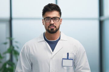 portrait of a male doctor standing in the lobby and looking ahead